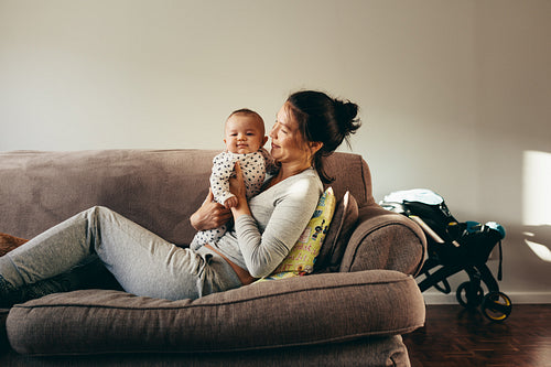 Mother sitting on couch with her baby