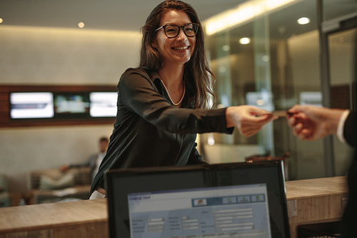 Business woman receiving key card for hotel room