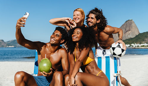 Friends capturing summer memories while playing altinha on a sunny beach day