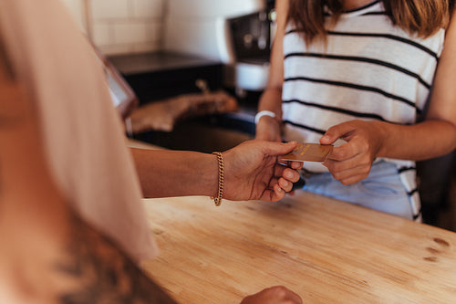 Woman entrepreneur accepting payment by card at the billing counter