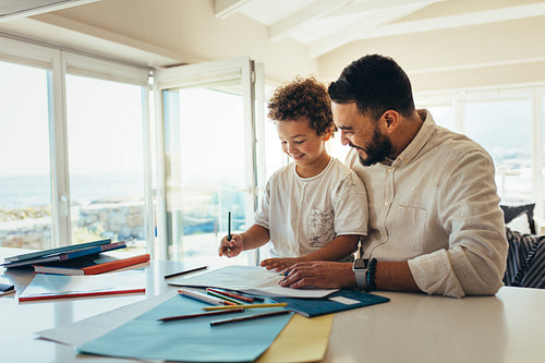 Man helping his son in doing homework