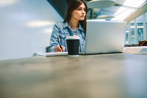 Female student doing homework in college campus