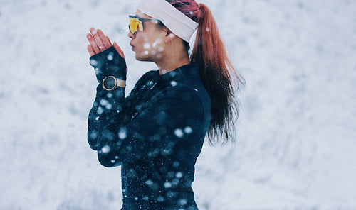 Winter athlete stands outdoors in snow with sportswear and sunglasses