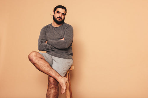 Confident young man sitting with his arms crossed