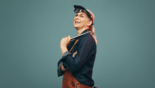 Happy jewellery maker smiling cheerfully in a studio
