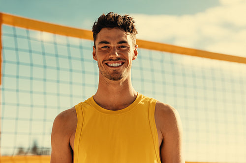 Australian male athlete smiling at camera during beach volleyball match on coastal summer games