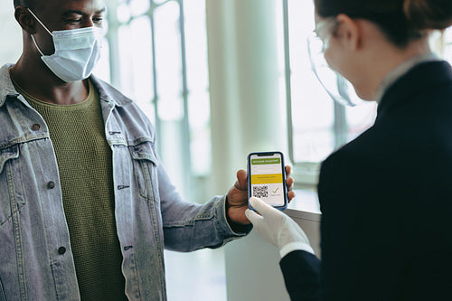 Passenger showing vaccine passport to airport staff