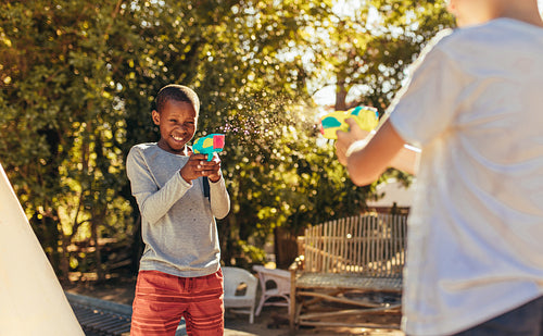 Children enjoys playing with squirt guns outdoors