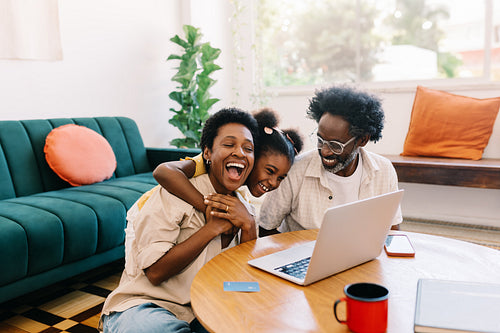 Happy black family having fun watching a video together