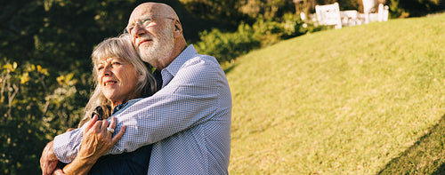 Elderly couple embracing each other in a park