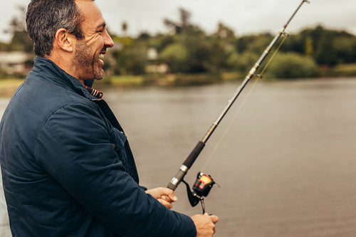 Happy man fishing in a lake