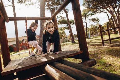 Twin sisters enjoying at playground