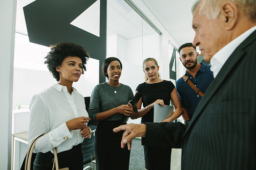 Business group talking in office corridor