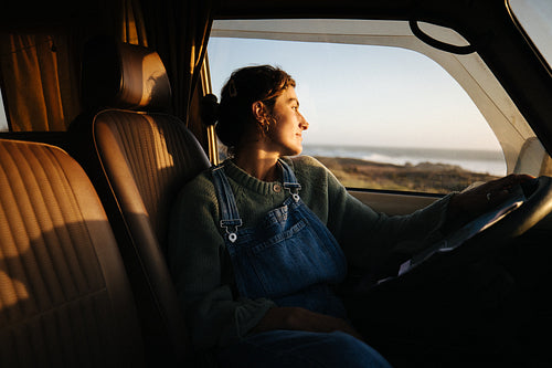 Calm driver looks toward coast through van window