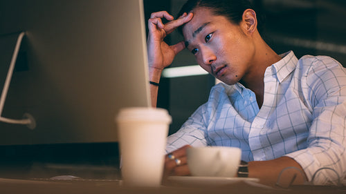 Businessman sitting in front of computer looking tensed