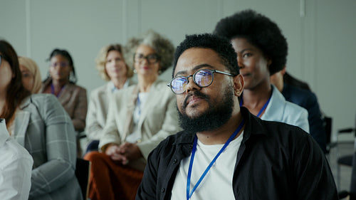Business professionals attentively listen during a conference, engaging with the speaker