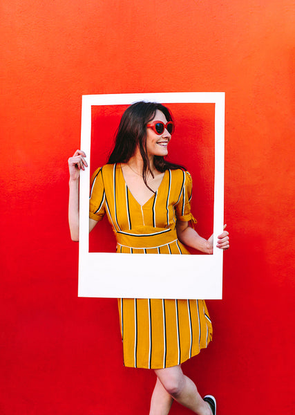 Beautiful woman posing with empty picture frame