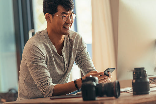 Happy photographer sitting at his workdesk 