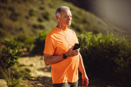 Fitness man listening to music and walking outdoors