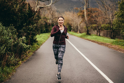 Female jogging on road in morning