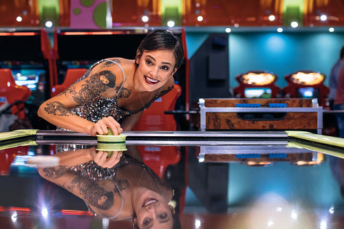 Woman playing air hockey game at a gaming arcade