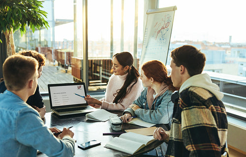 Student giving presentation on laptop to classmates