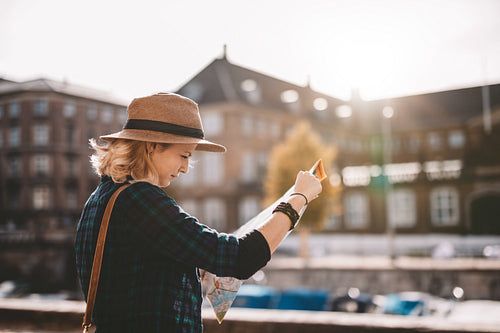 Young tourist woman looking at a navigation map.