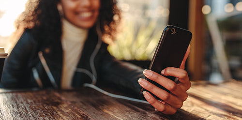 Woman sitting at  table holding a smartphone