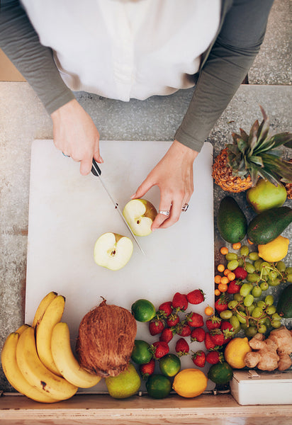 Female employee working at juice bar cutting an apple