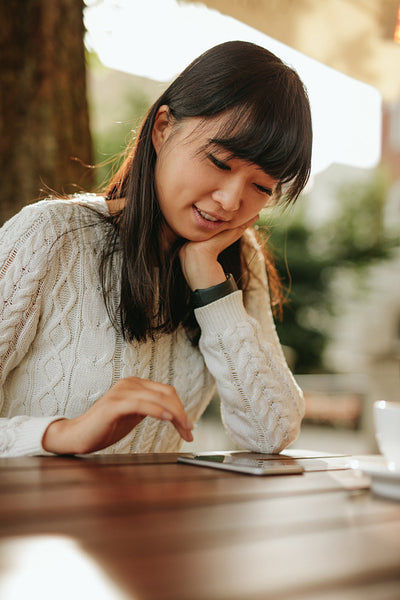 Beautiful lady using smartphone at outdoor cafe