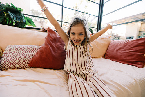 Happy girl on couch with arms raised