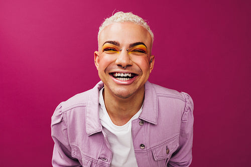 Confident queer man smiling in a studio