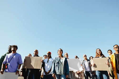 Group of diverse individuals demonstrating for a cause under a clear sky