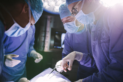 Female surgeon with her team performing surgery on patient