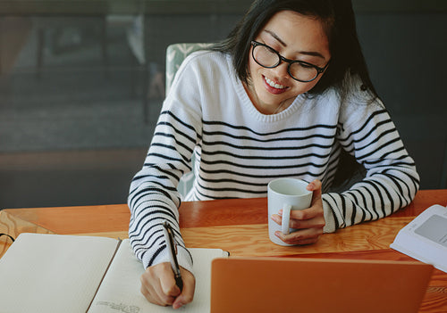 Woman writing notes in diary
