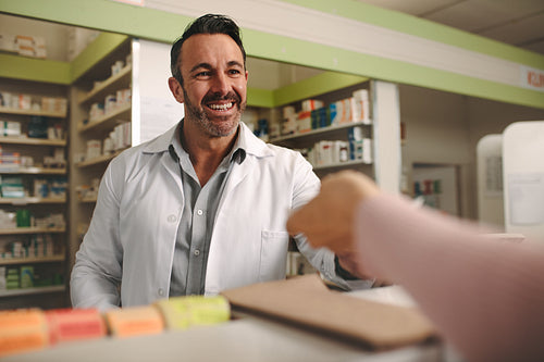 Chemist assisting customer at pharmacy store