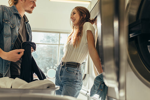 Couple standing in a laundry room looking at each other