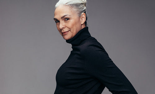 Confident senior lady on grey background