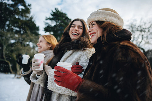 Friends share hot chocolate during a snowy day out
