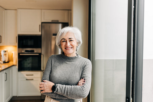 Grey-haired woman smiling happily at home