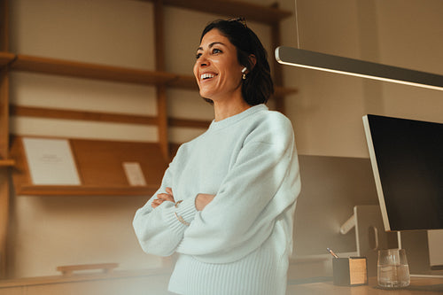Woman stands smiling in an office for a business portrait