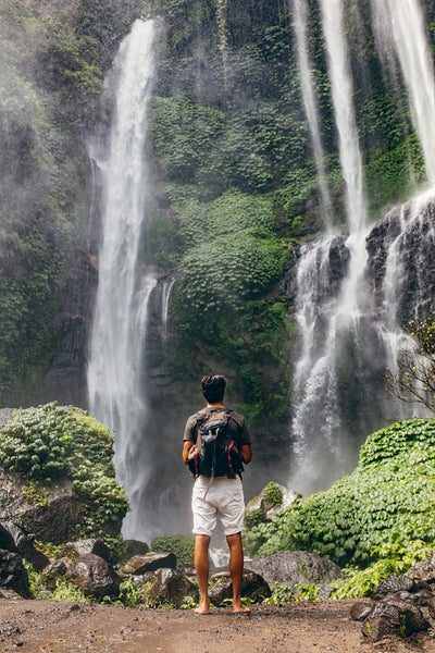 Young male hiker looking at waterfall