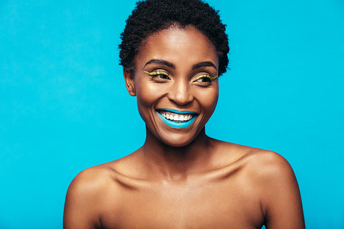 Smiling african woman wearing vivid makeup