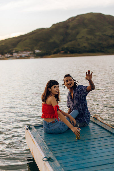 Adventuruos young couple greeting someone on a ship