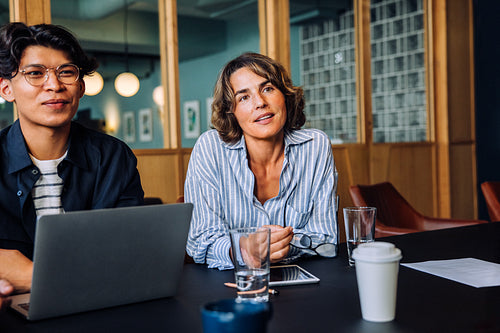 Two professionals discussing a project during a meeting in a stylish office