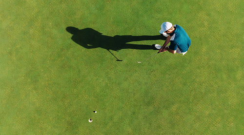Aerial view of a man putting a golf shot on the green