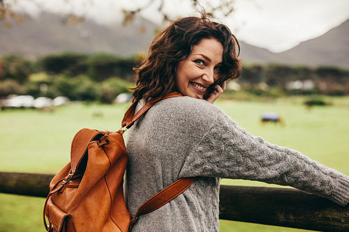 Woman standing by a fence of a ranch.