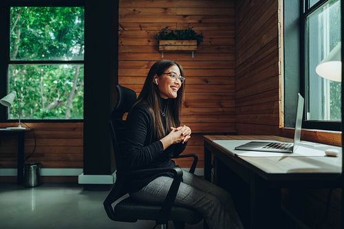 Cheerful businesswoman having a virtual meeting in a coworking s