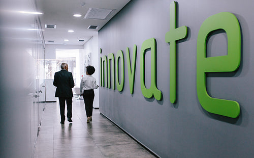 Business colleagues walking in office hallway