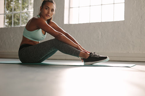 Healthy woman taking break after workout in gym